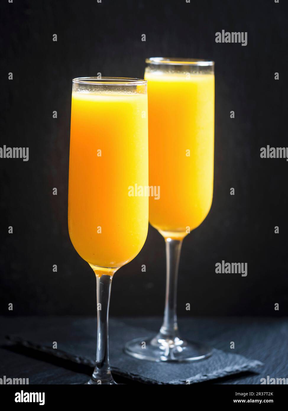Zwei Gläser frisch gepresster Orangensaft vor schwarzem Hintergrund Stockfoto