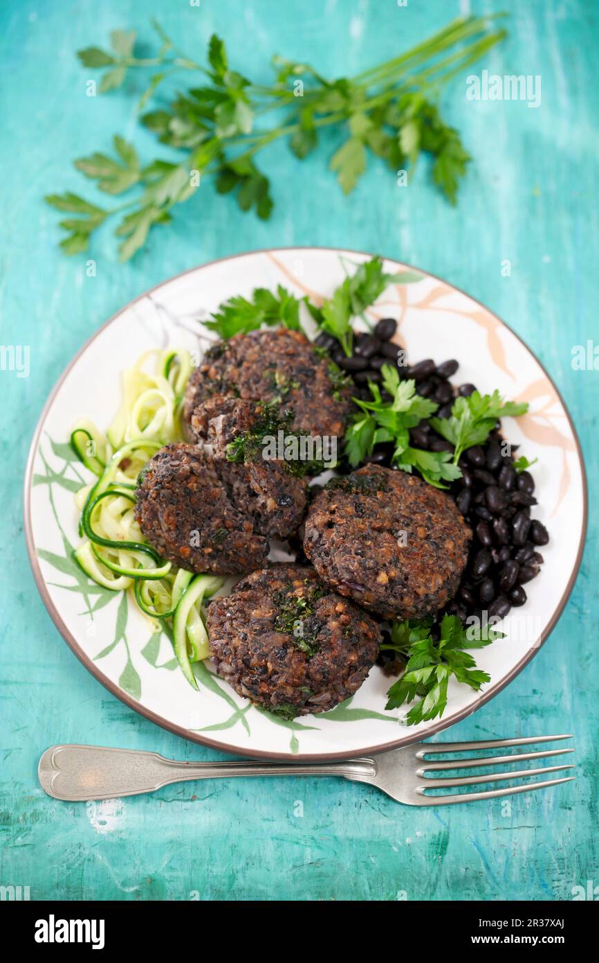 Buchweizenpasteten mit schwarzen Bohnen und Zucchini-Nudeln Stockfoto