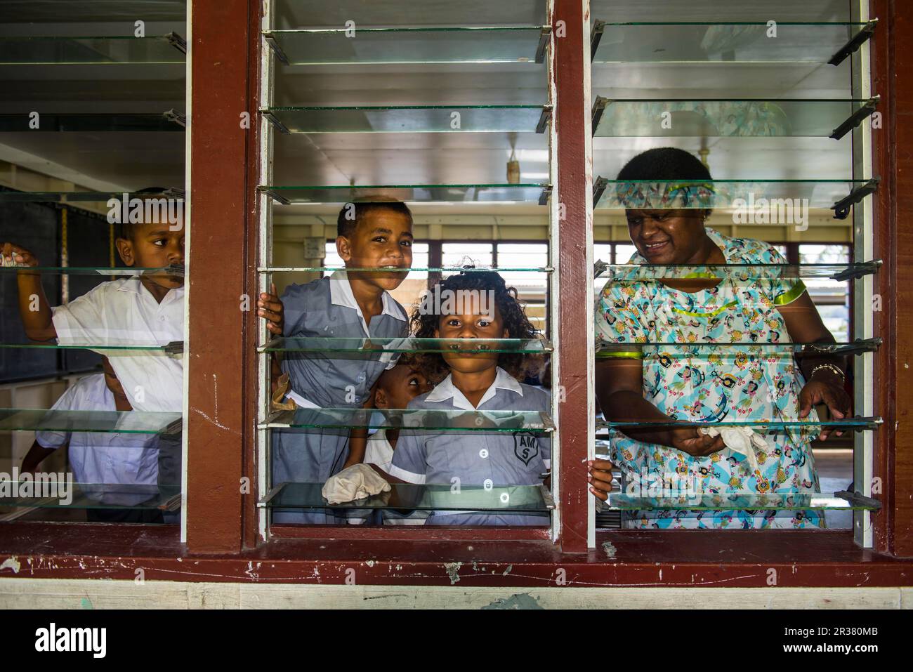 Der Schuljunge putzt die Fenster ihrer Schule, Yanuya Insel, Mamanuca Inseln, Fidschi Stockfoto