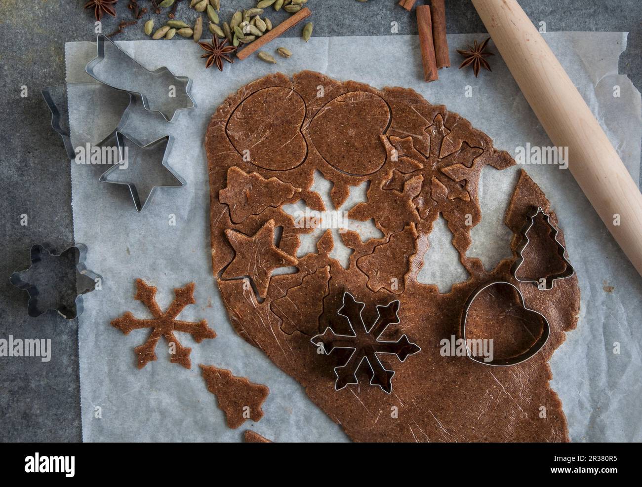 Vegane Lebkuchen, die aus einem ausgerollten Gebäckstück geschnitten werden (von oben gesehen) Stockfoto