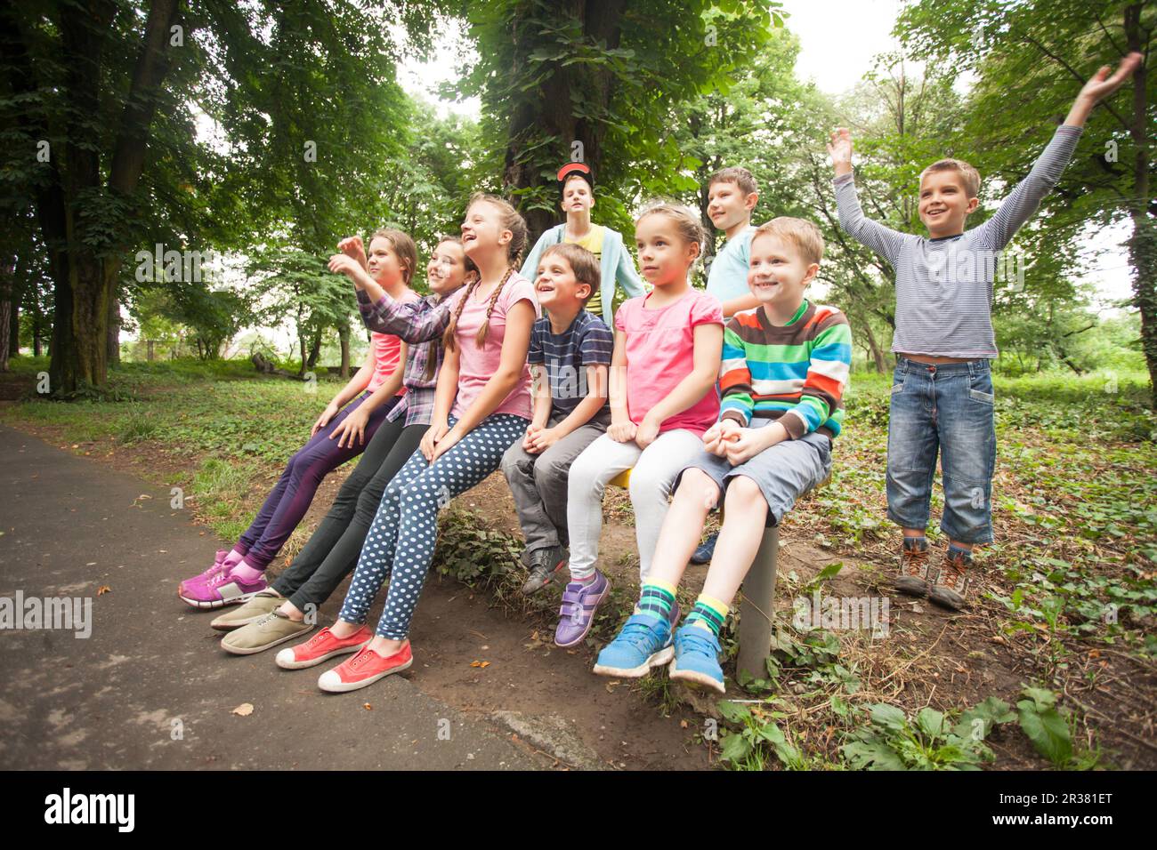 Gruppe von Kindern auf einer Parkbank Stockfoto