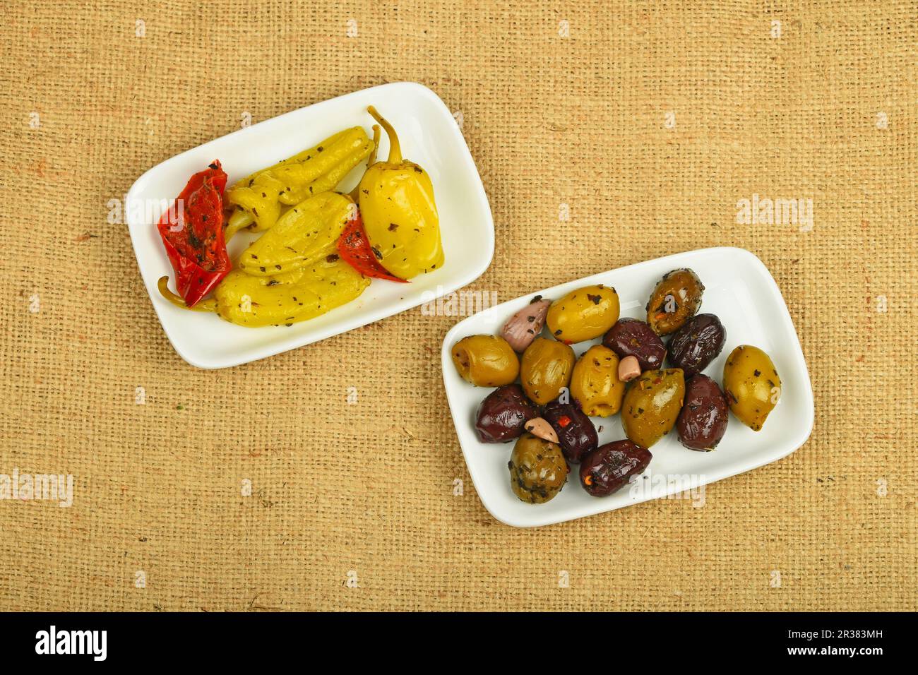 Mediterraner Imbiss mit Oliven und eingelegtem Pfeffer auf Leinwand Stockfoto