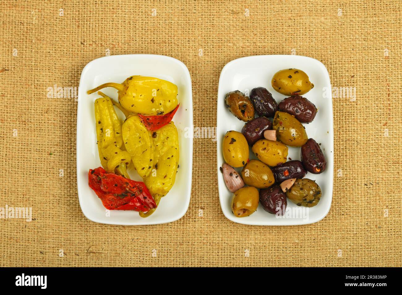 Mediterraner Imbiss mit Oliven und eingelegtem Pfeffer auf Leinwand Stockfoto