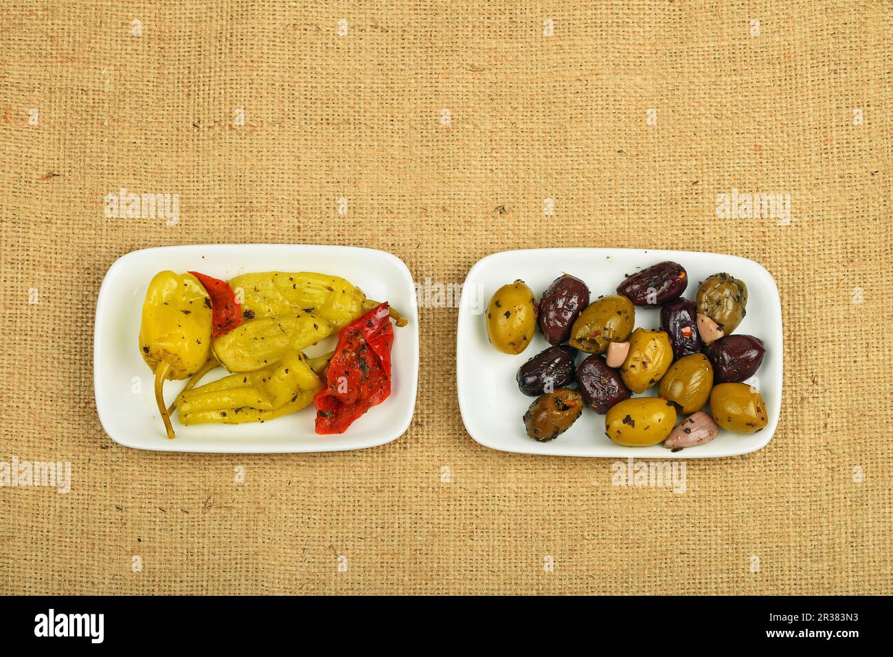 Mediterraner Imbiss mit Oliven und eingelegtem Pfeffer auf Leinwand Stockfoto