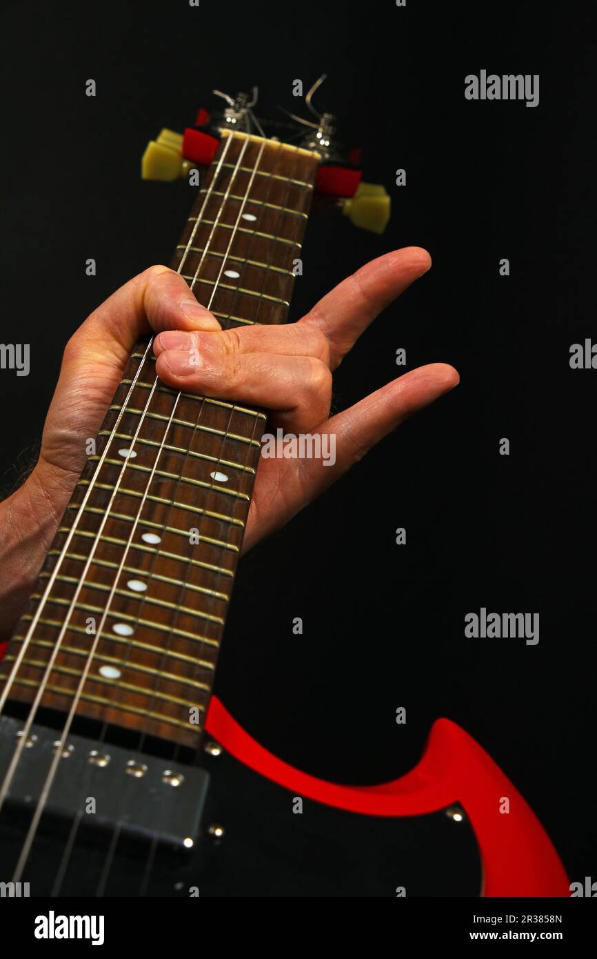 Hand mit roten Gitarre und Teufel Hörner isoliert auf Schwarz Stockfoto Hand mit roten Gitarre und Teufel Hörner isoliert auf Schwarz Stockfoto