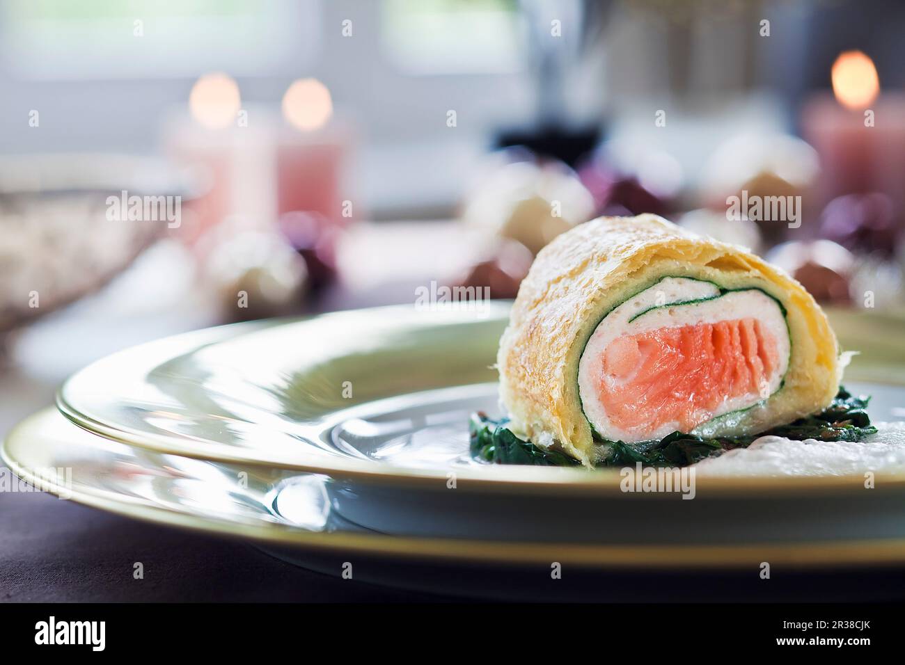 Lachsstrudel auf Spinat zu Weihnachten Stockfoto