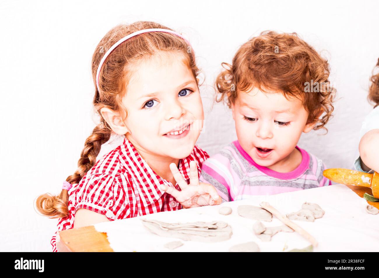 Glückliche Kinder sind beschäftigt mit Knetmasse Stockfoto