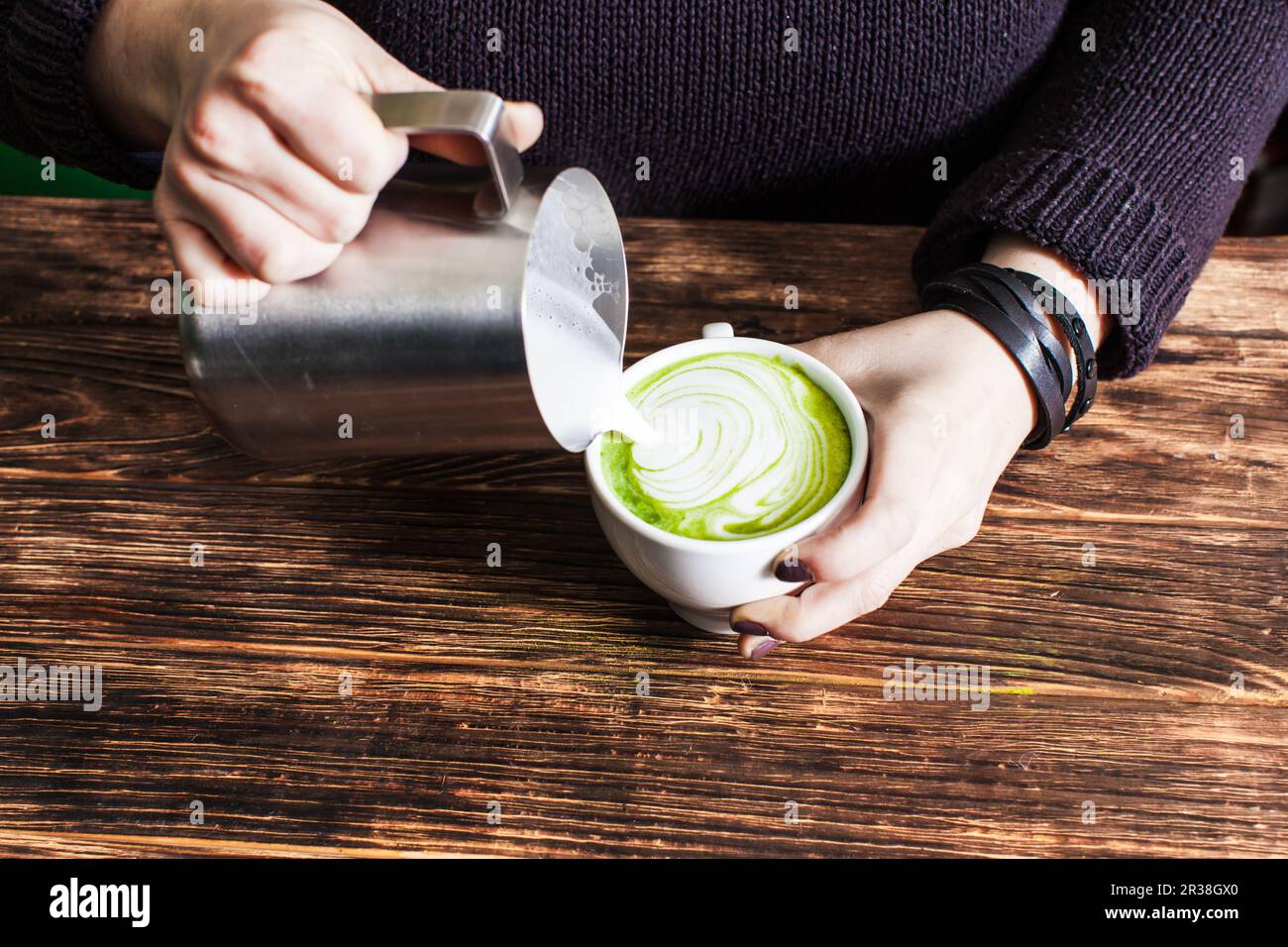 Prozess der Abfüllung von Milch in Matcha Schale Stockfoto