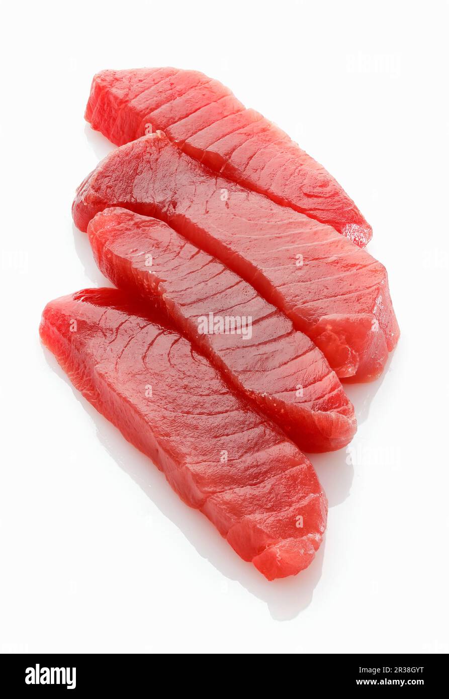 Vier frische Thunfisch-Steaks auf einer weißen Oberfläche Stockfoto