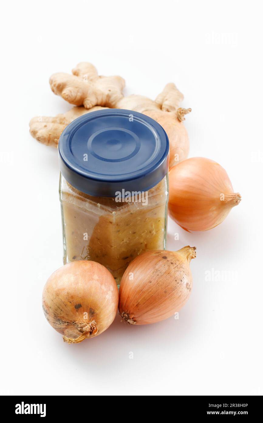 Ingwer- und Zwiebelmarmelade in einem Mixbecher auf einer weißen Oberfläche Stockfoto