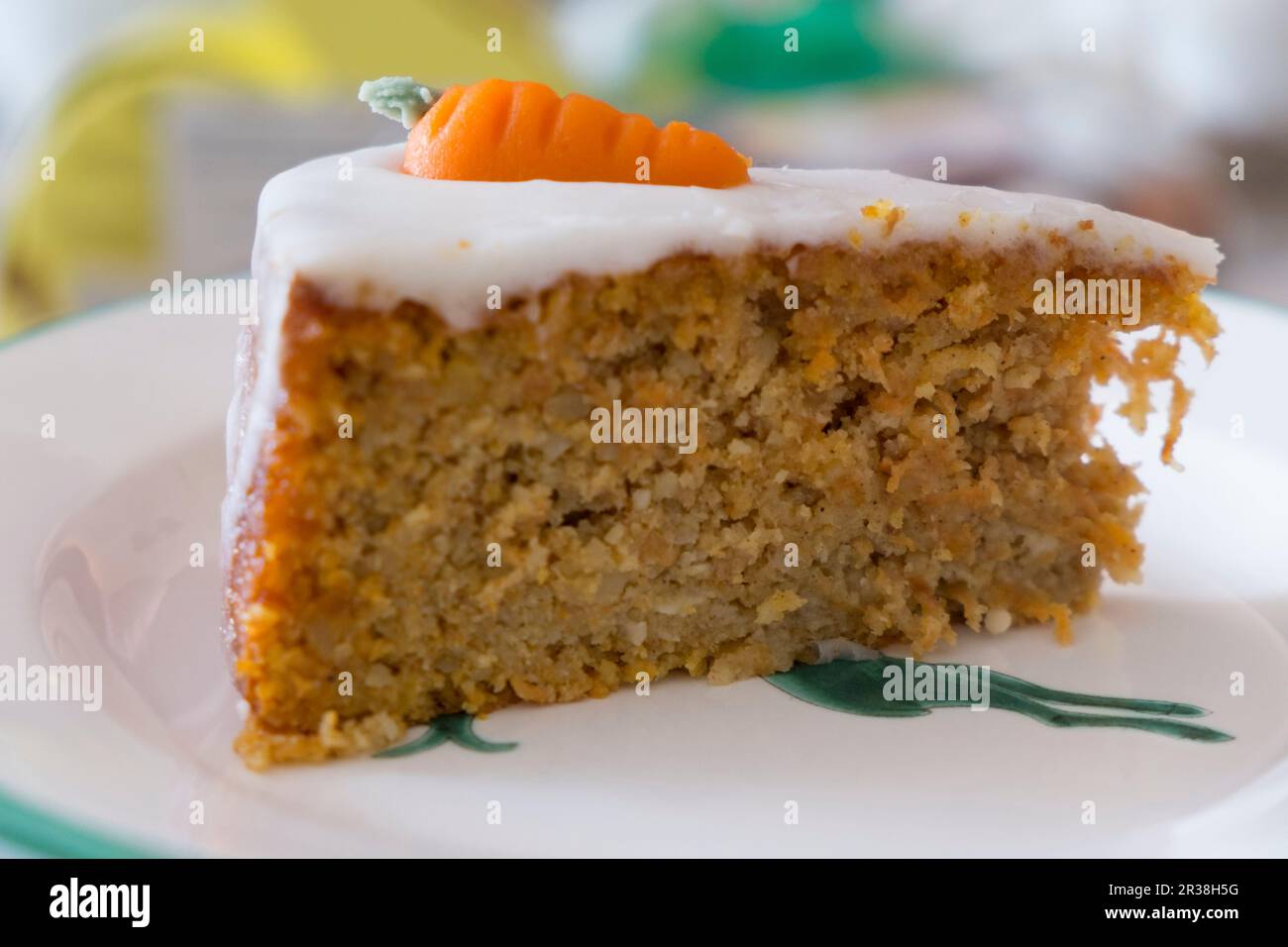 Eine Scheibe Karottenkuchen mit Sahnehäubchen und Marzipan-Karotten Stockfoto