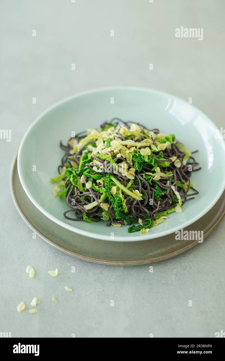 Nudeln aus schwarzen Bohnen mit wirsing und gebratenem grünen Reis (vegan) Stockfoto