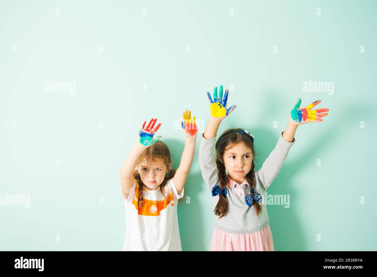 Zwei kleine Mädchen schwenkten ihre gemalten bunten Händen Stockfoto
