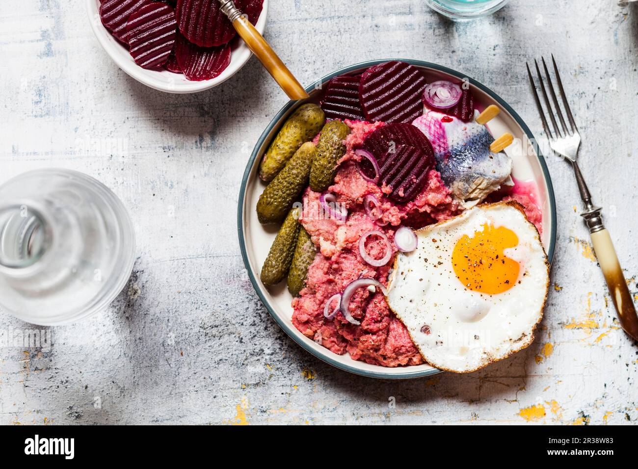 Lobscouse mit Hering, Spiegelei, Rote Bete und Gewürzgurken Stockfoto