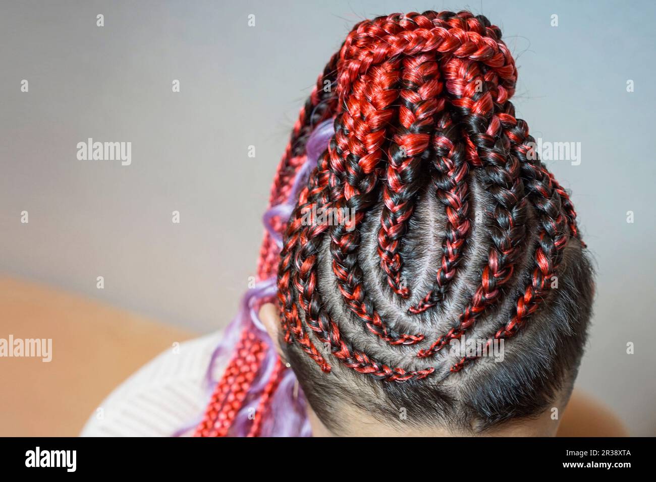 Cornrows Frauen häkeln wunderschöne Kanekalon-Locken, die mit einem Haken in das Haar gewebt sind, afrikanische Frisur mit künstlichem Haar Stockfoto