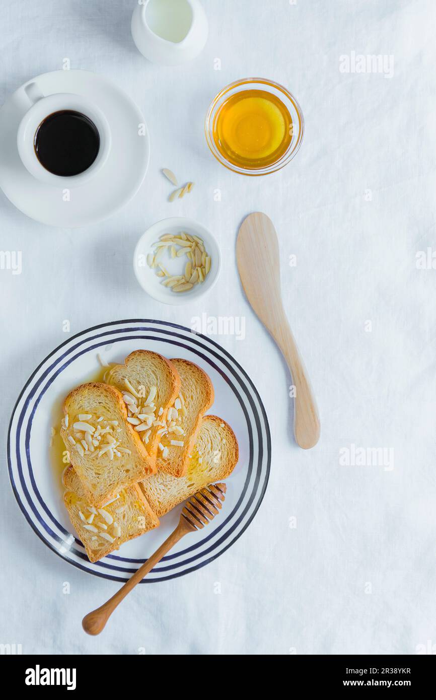 Melba Toast mit Honig und gehackten Mandeln Stockfoto