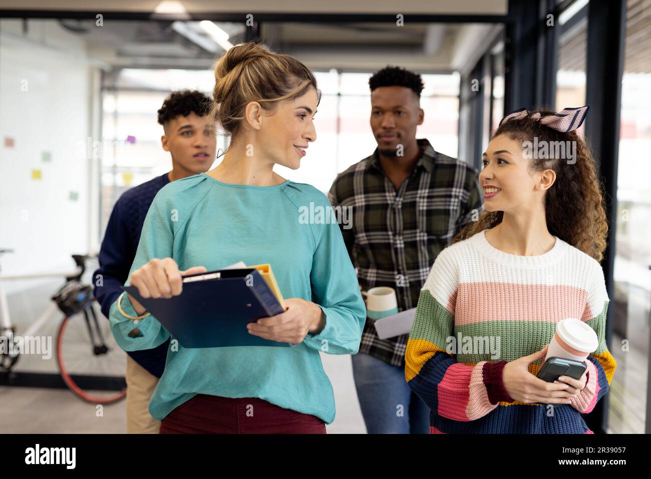 Vielbeschäftigte, vielfältige Geschäftsleute mit Dokumenten, die ihre Arbeit im Büro besprechen, unverändert Stockfoto