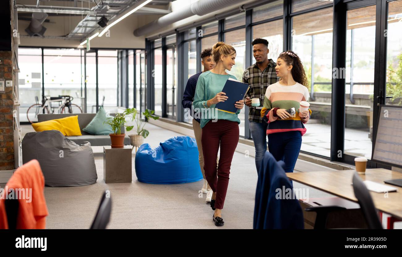 Vielbeschäftigte, vielfältige Geschäftsleute mit Dokumenten, die ihre Arbeit im Büro besprechen, unverändert Stockfoto