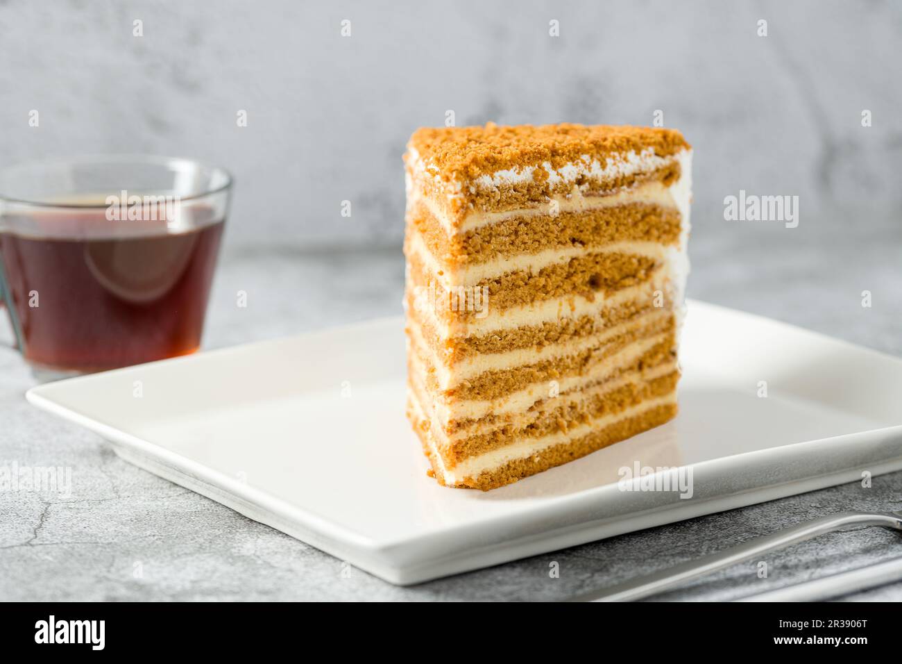 Geschichtetes Honigkuchen-Stück auf weißer Porzellanplatte auf Steinhintergrund Medovik Stockfoto