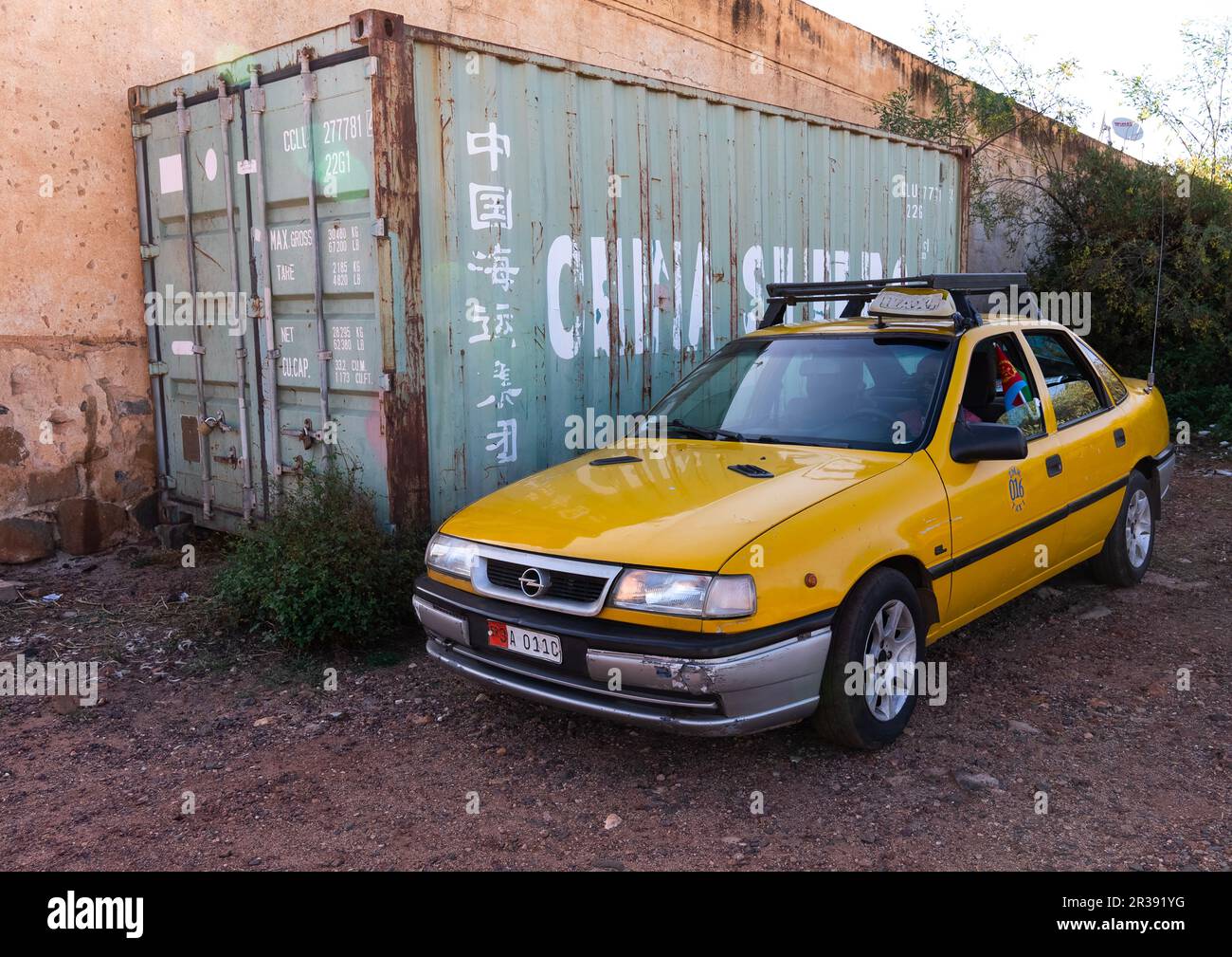 Eritreisches Taxi parkt in der Nähe eines chinesischen Containers, Zentralregion, Asmara, Eritrea Stockfoto