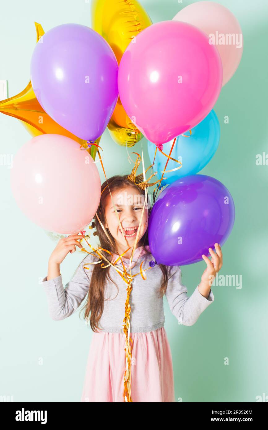 Hübsches Mädchen auf Geburtstagsparty mit Ballons Stockfoto