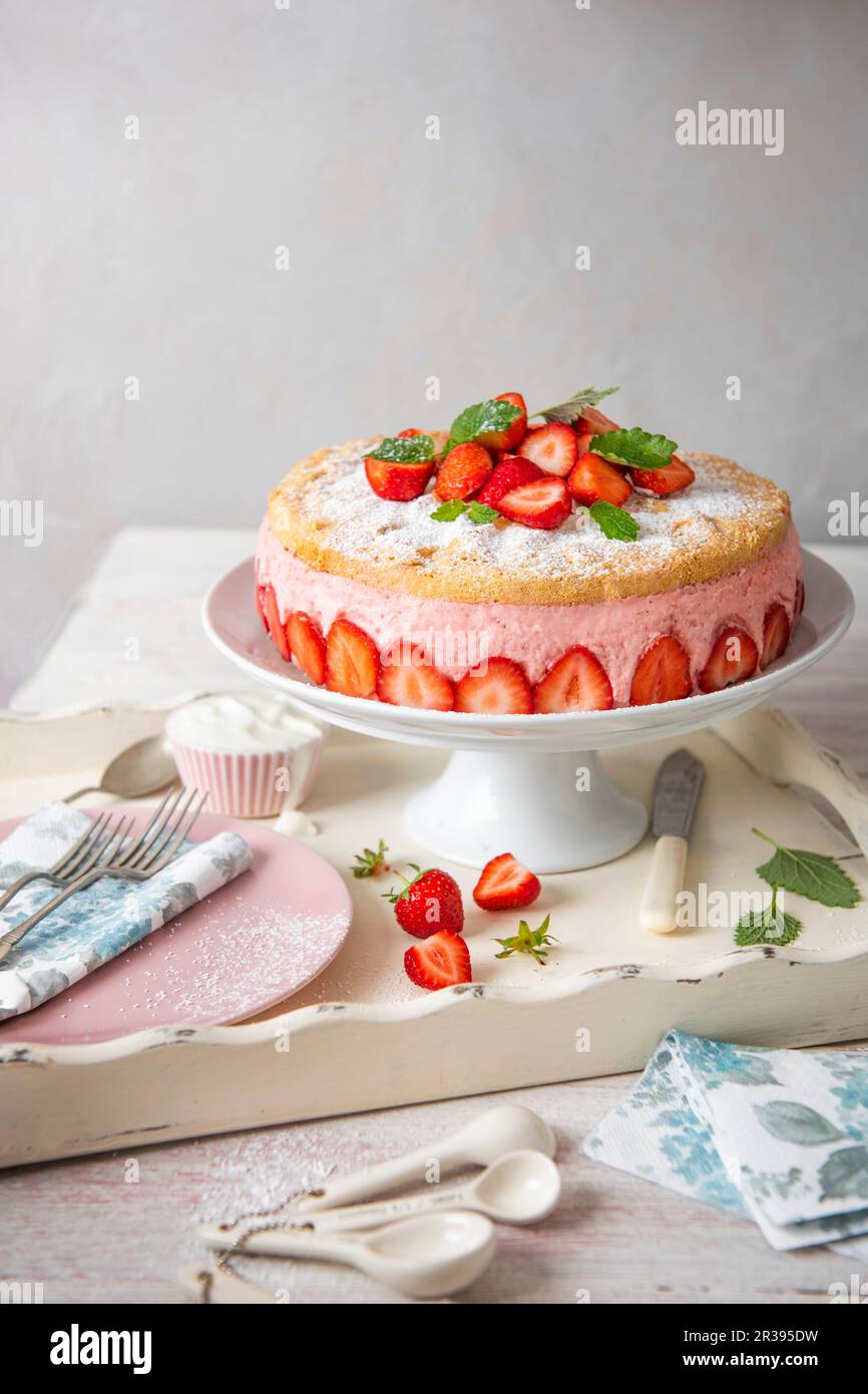 Kuchen mit Erdbeermousse und Genoisschwamm mit frischen Erdbeeren Stockfoto