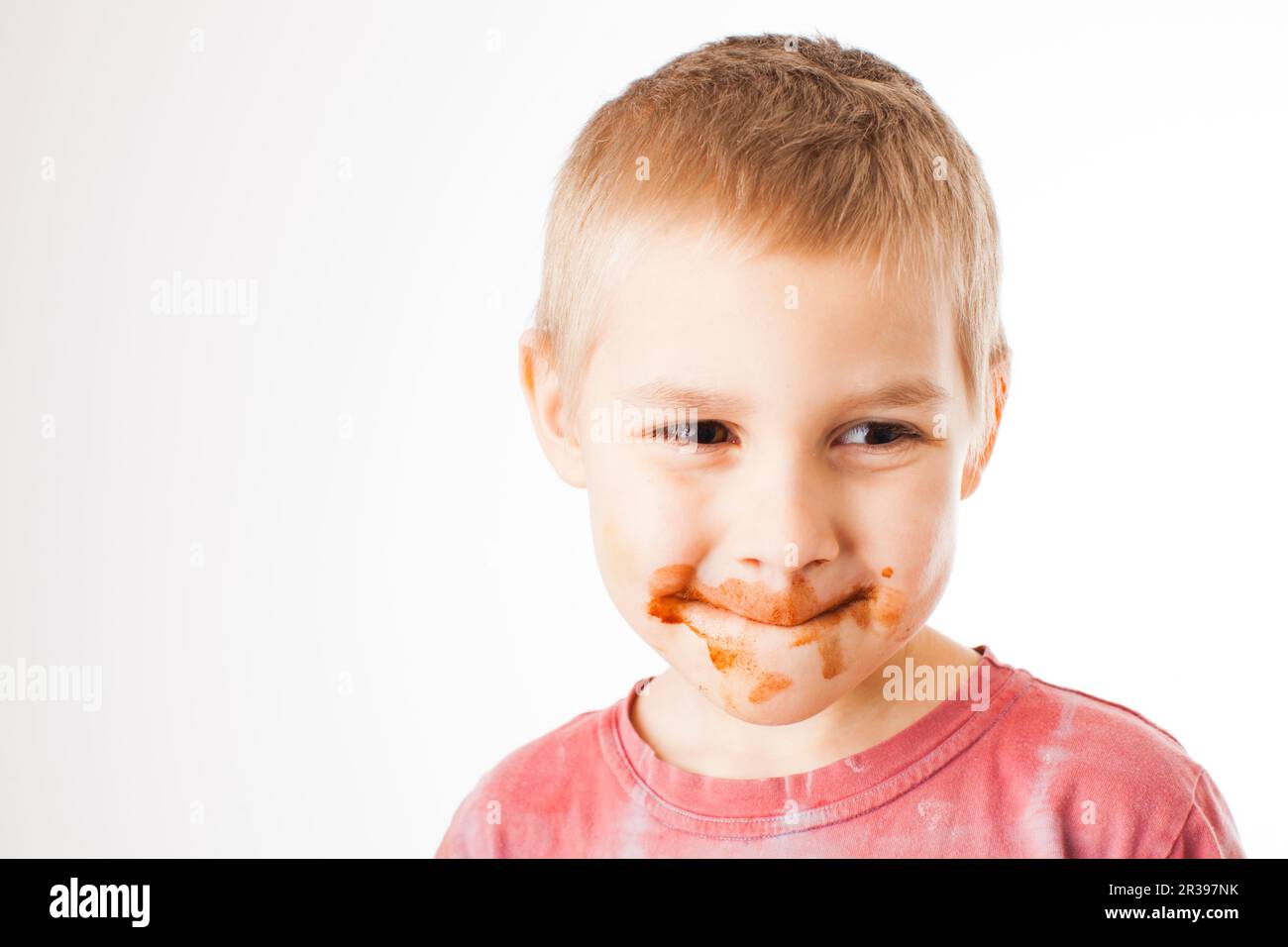 Porträt der blonde Junge mit Schokolade auf seinem Gesicht isoliert auf weißem Stockfoto