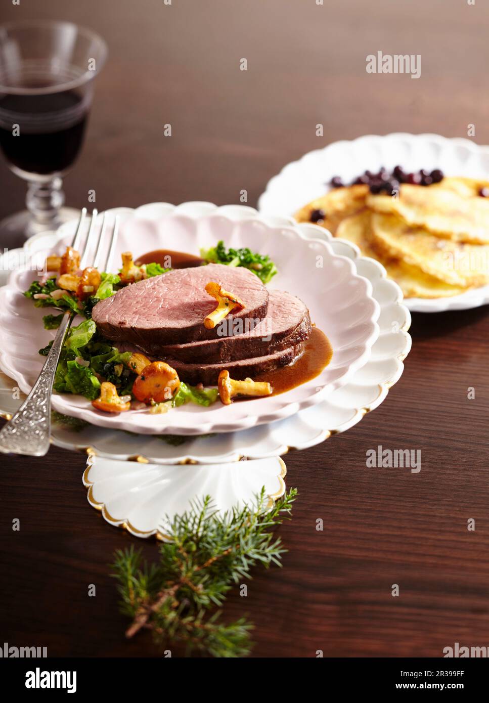Gerösteter Sattel mit wirsing, Pfifferling und Heidelbeerpfannkuchen Stockfoto