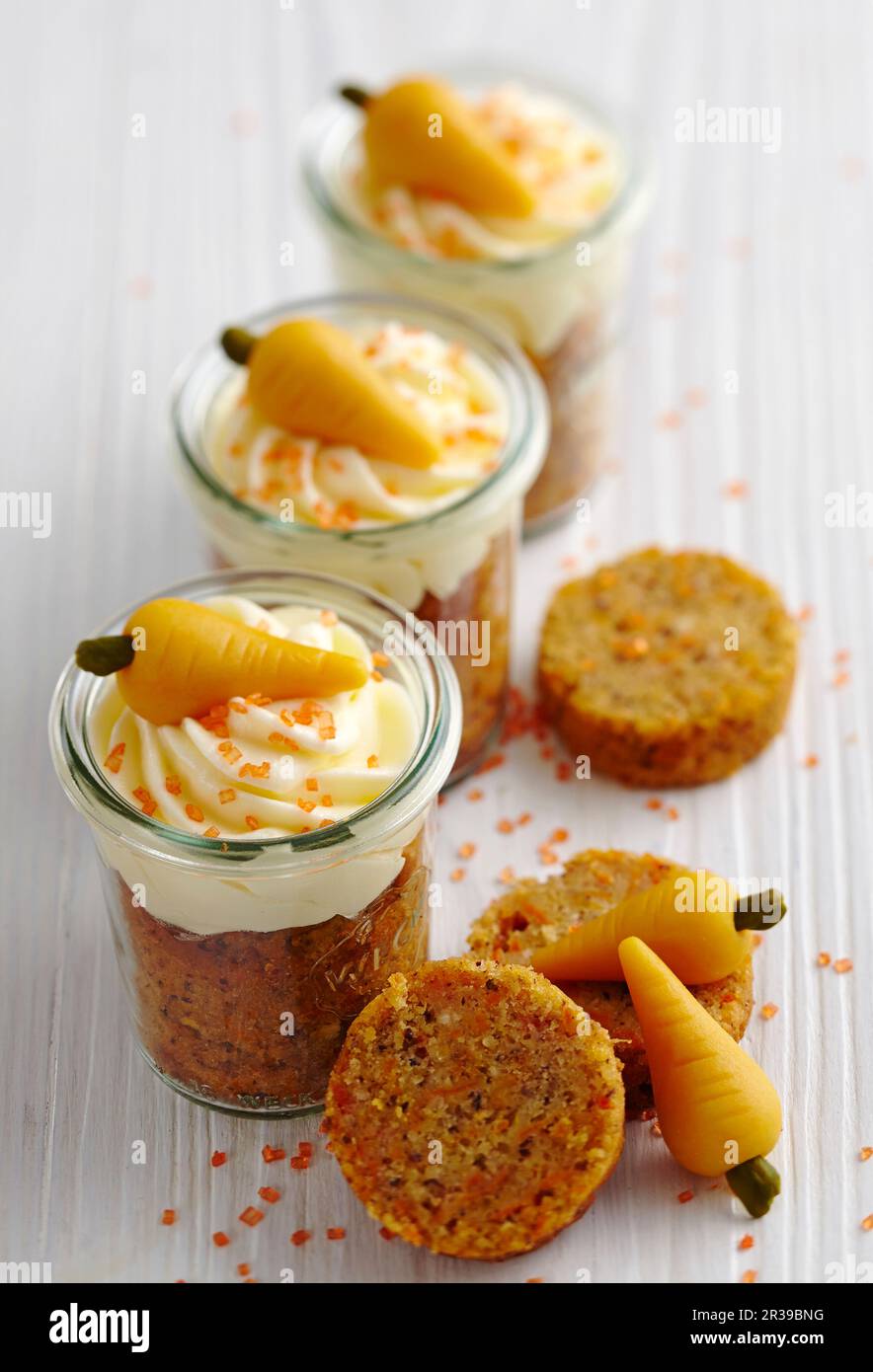 Karotten-Muffins mit Frischkäse und Marzipan-Karotten in Maurergläsern für den Osterbrunch Stockfoto