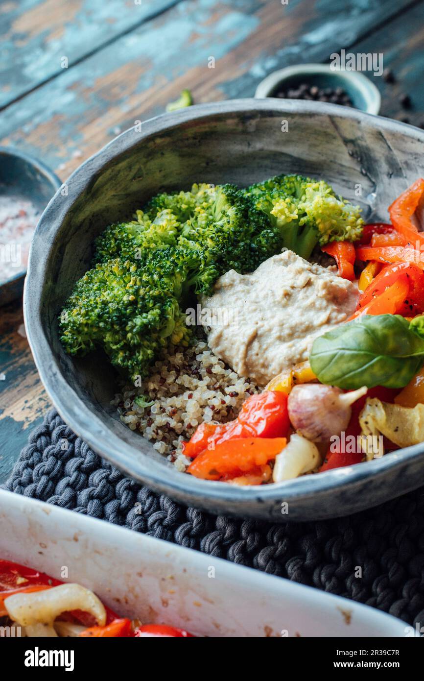 Geröstete Paprika, Brokkoli, Quinoa und Hummus Stockfoto