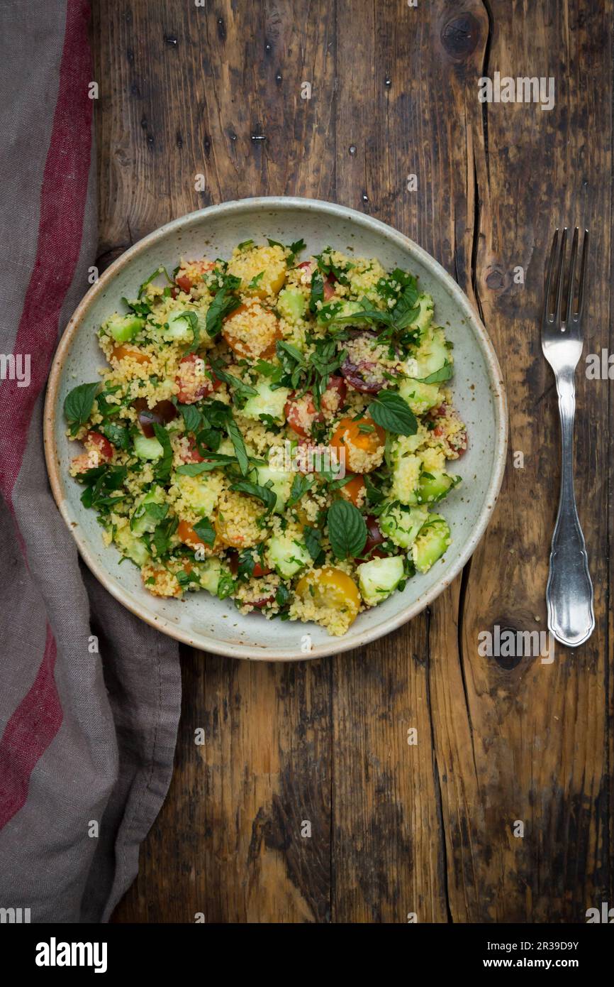 Tabbouleh (Couscous-Salat mit Tomaten, Gurken, roten Zwiebeln, Petersilie und Minze) Stockfoto