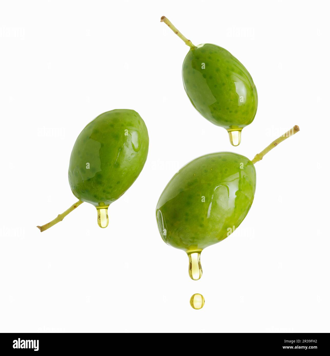 Olivenöl tropft aus grünen Oliven Stockfoto
