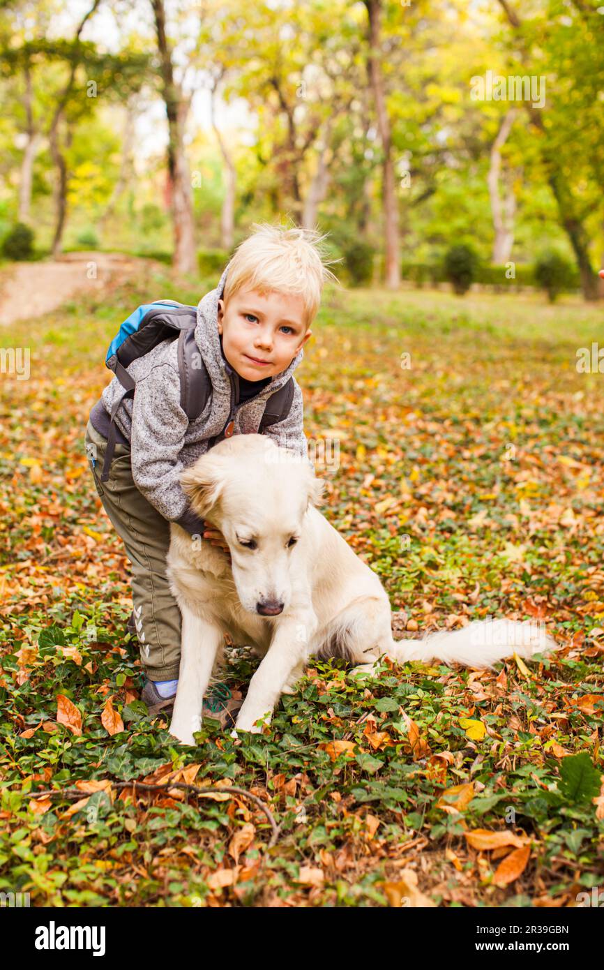Kleiner Tierliebhaber auf einem Herbstspaziergang mit Haustierhund Stockfoto