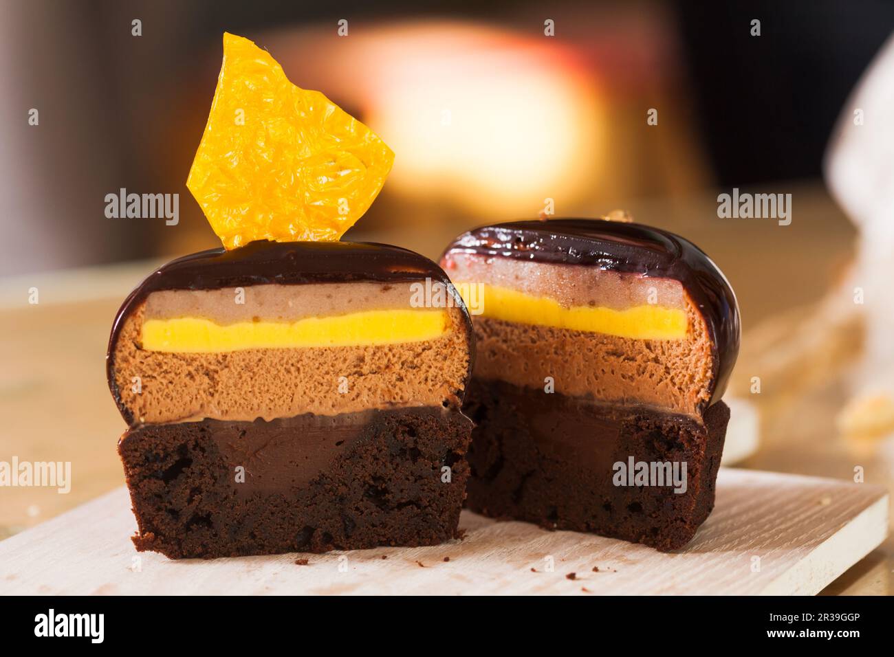 Die Hälfte des französischen Mousse-Portion-Kuchens ist mit Schokoladenglasur bedeckt Stockfoto