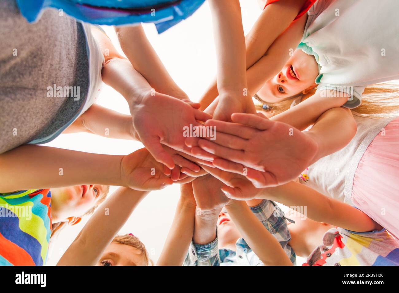 Glückliche Kinder, die ihre Arme nah beieinander halten Stockfoto