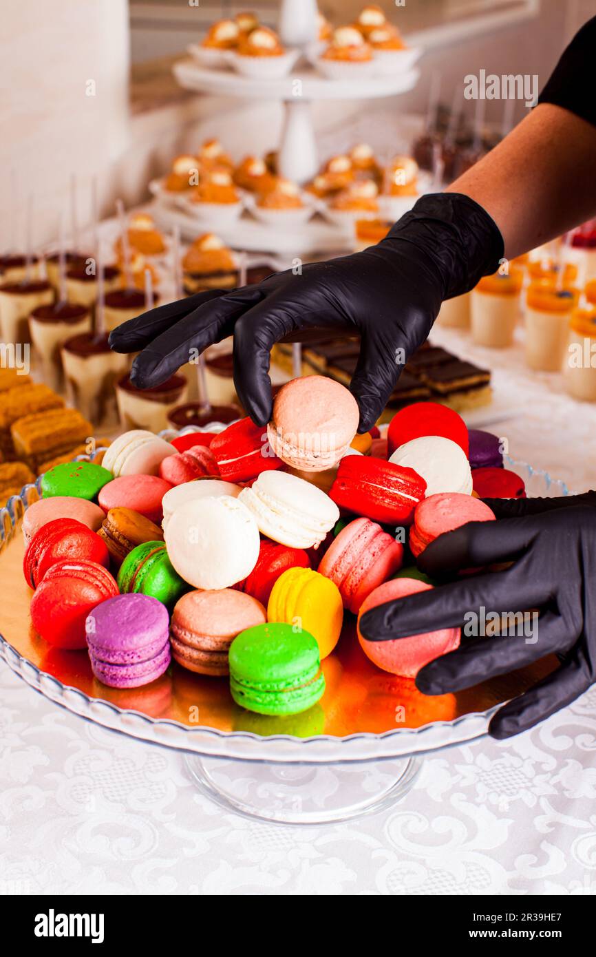 Catering-Bar zum Feiern. Bunte Makronen auf einem Teller. Leckere Desserts auf dem Tisch Stockfoto