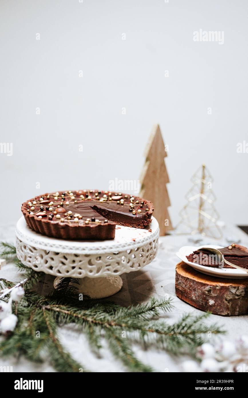 Schokoladenkuchen auf einem Kuchen stehen auf einem für Weihnachten dekorierten Tisch Stockfoto