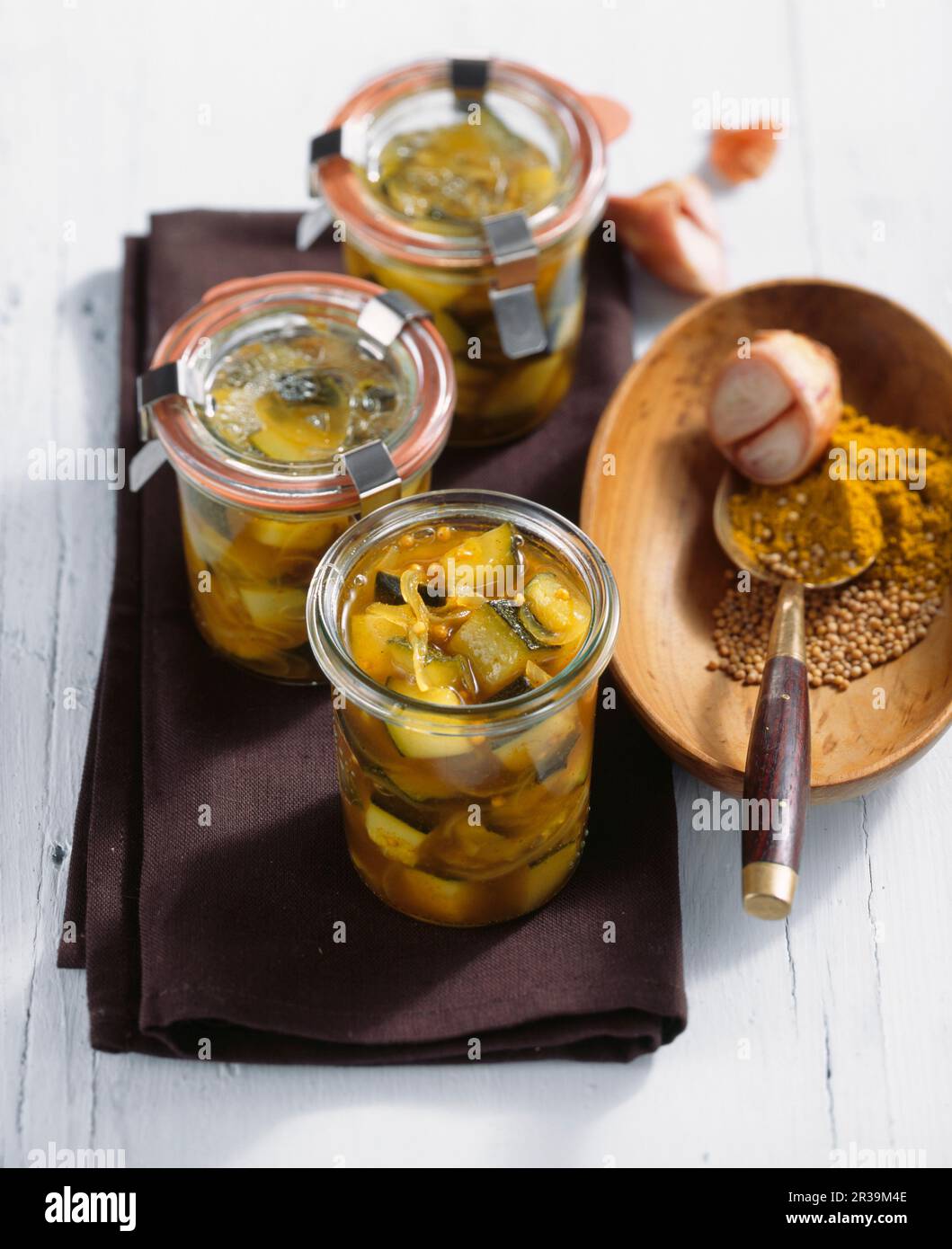 Eingelegte Curryzucchini in Weißweinessig, Paprika und Senf in Gläsern Stockfoto