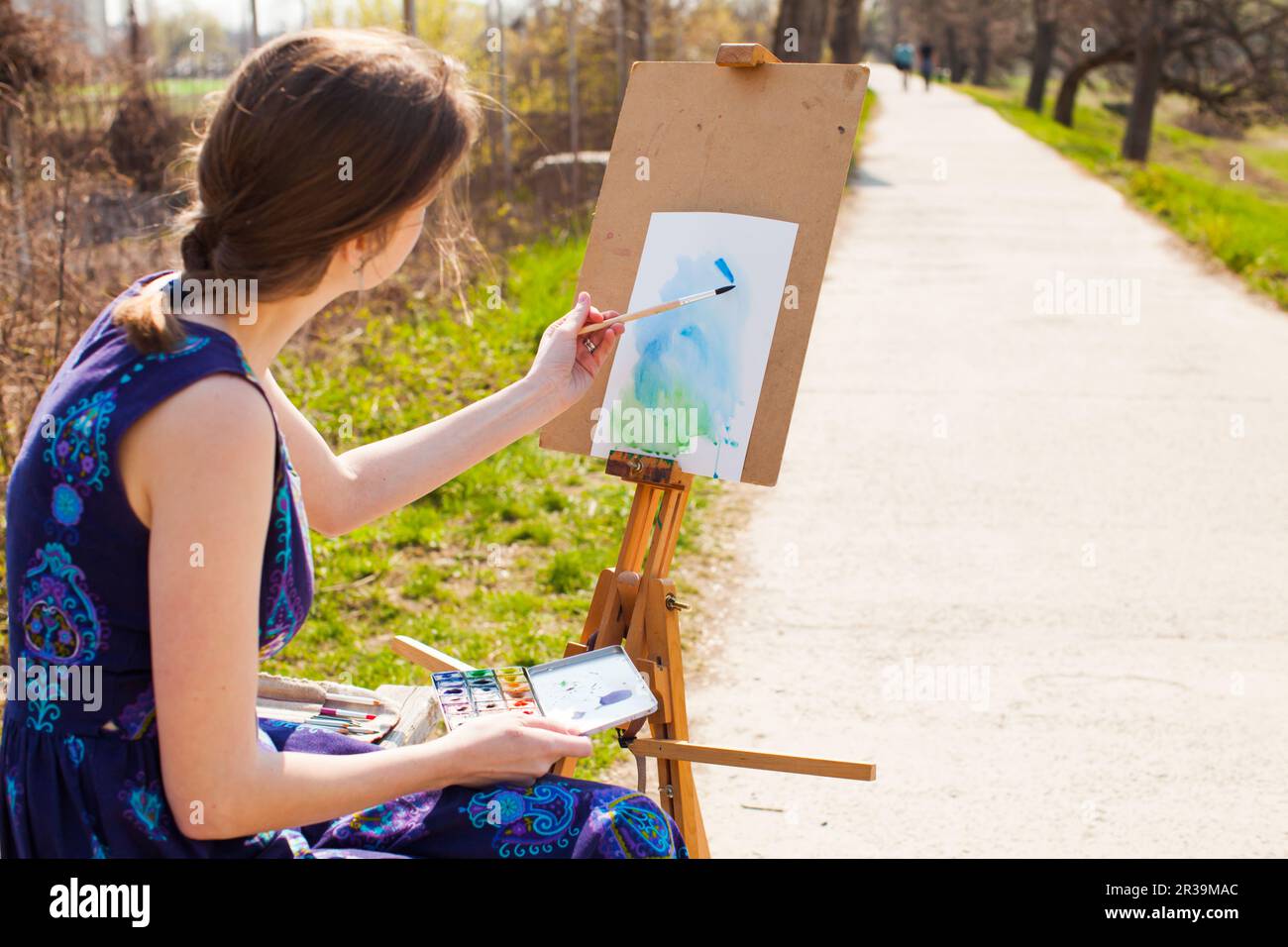 Junge Künstlerin malt Bild im Frühlingspark. Stockfoto