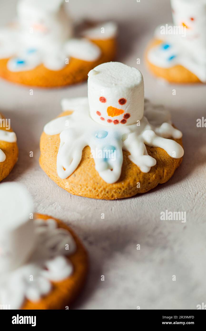Weihnachtsbacken für Kinder. Lustiger schmelzender Schneemanger-Lebkuchen für Party Stockfoto