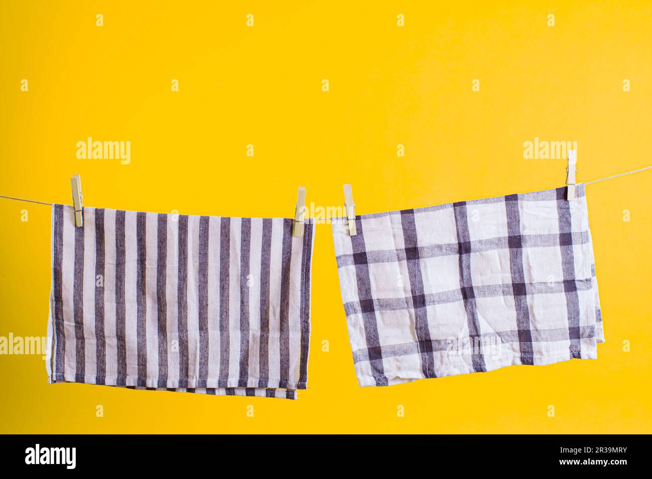 Umweltfreundliche Haushaltsgegenstände. Gewaschene Handtücher mit Holzkleidern, die am Seil hängen Stockfoto