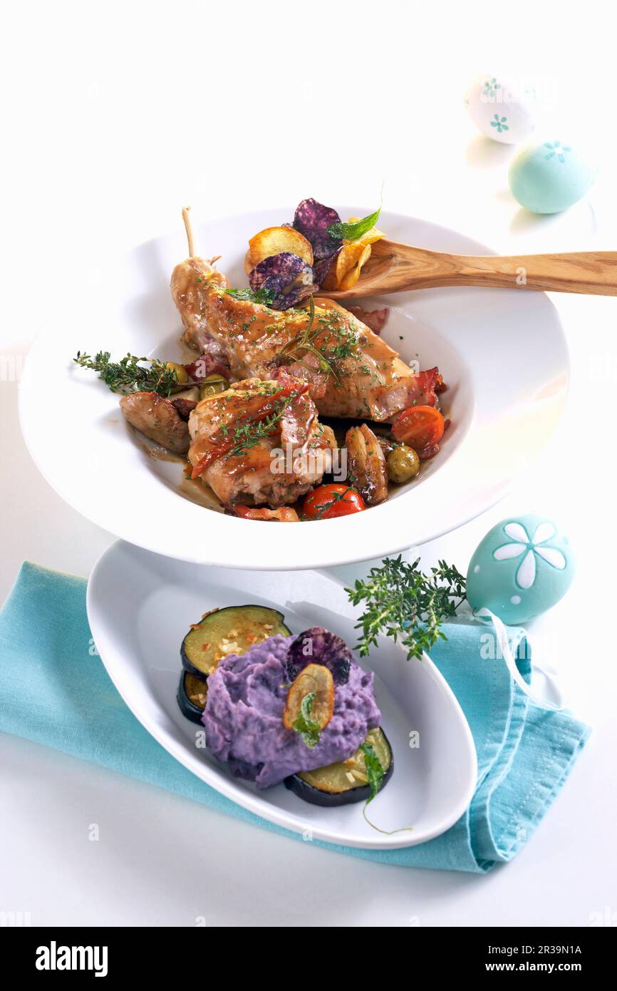 Geschmortes Kaninchen mit balsamischen Schalotten und lila Kartoffelpüree auf einem Bett Auberginen zu Ostern Stockfoto
