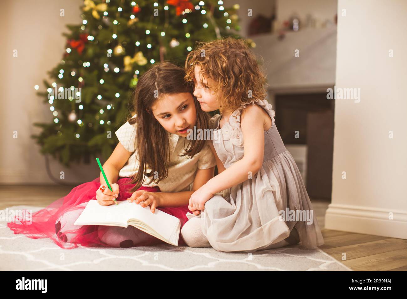 Mädchen teilen ihre Träume am Weihnachtssabend Stockfoto