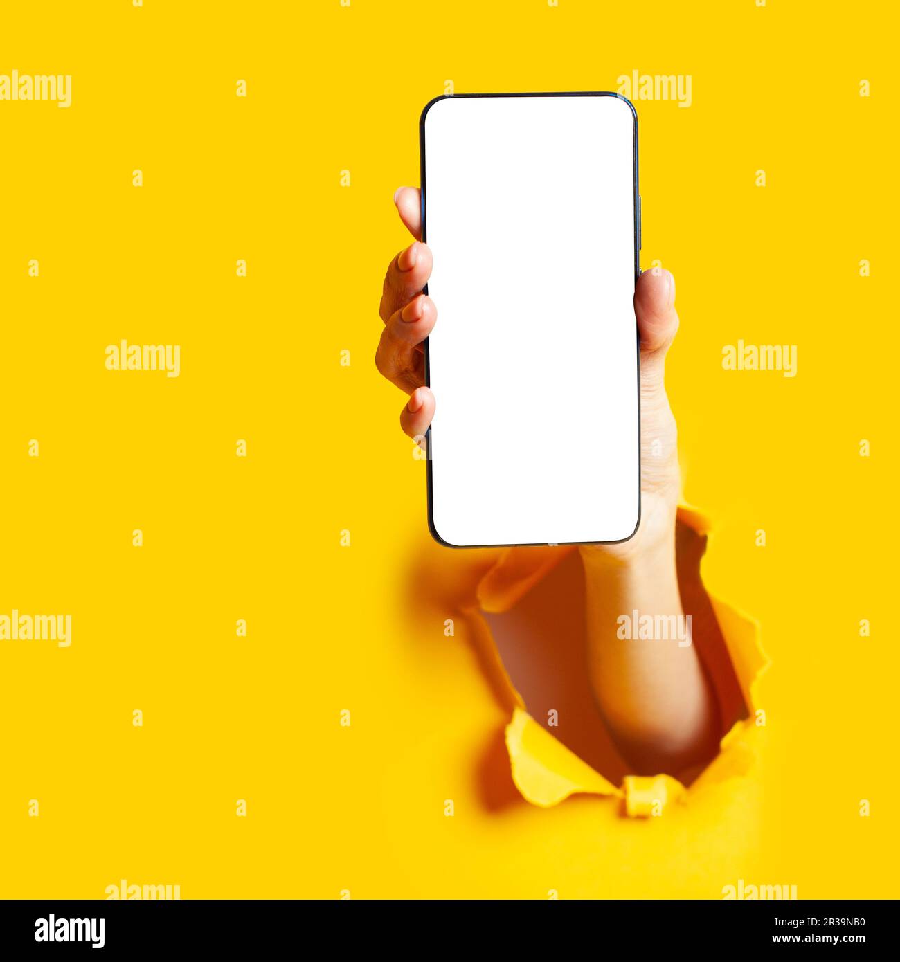 Frau Hand in die Papieröffnung, die das Smartphone hält. Mobile Anwendung. Stockfoto