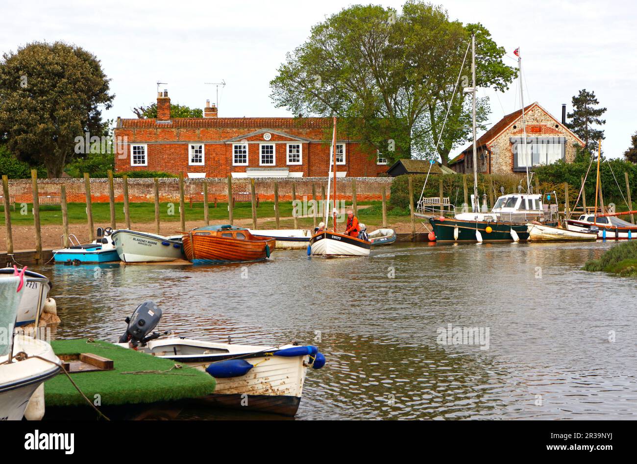 Ein kleines Schiff, das die Kurve von Agar Creek in den Hafen an der Nordnorfolkküste bei Blakeney, Norfolk, England, Vereinigtes Königreich umrundet. Stockfoto