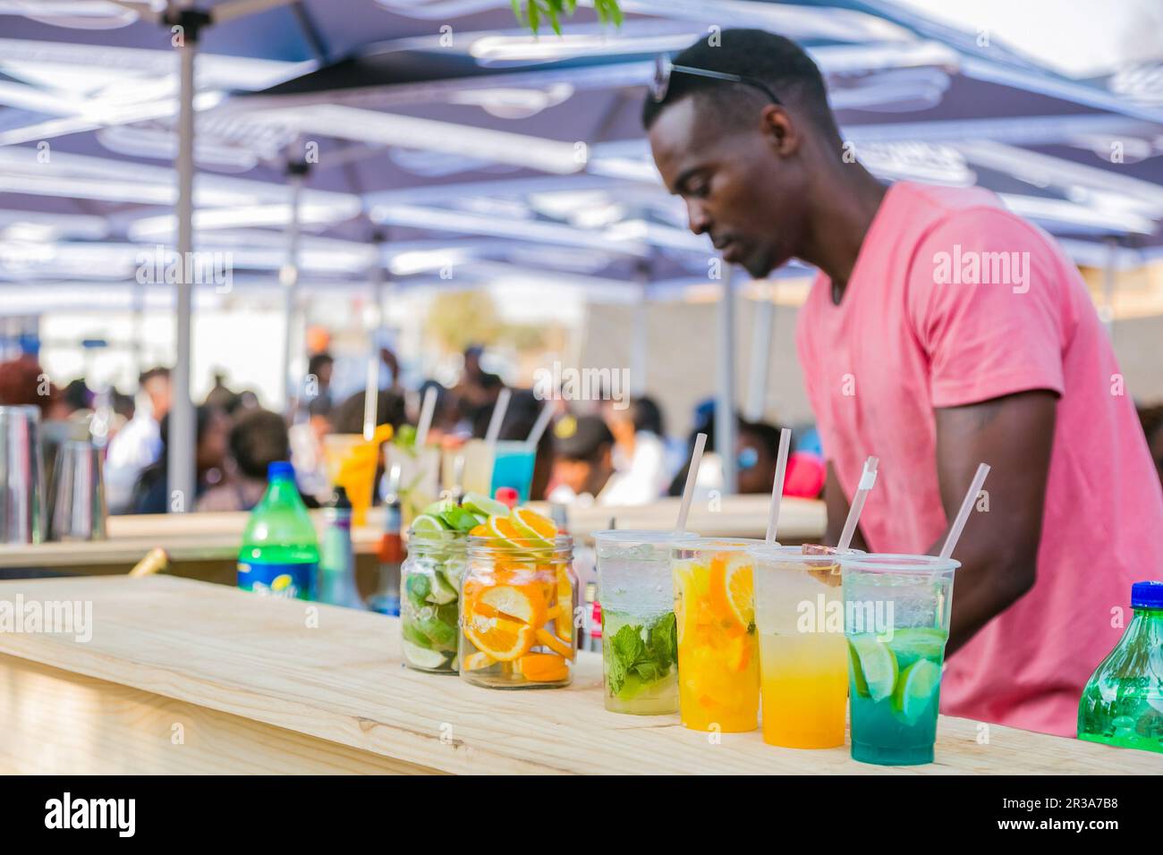 Vielfältiger afrikanischer Verkäufer, der Cocktails beim Outdoor Festival serviert Stockfoto