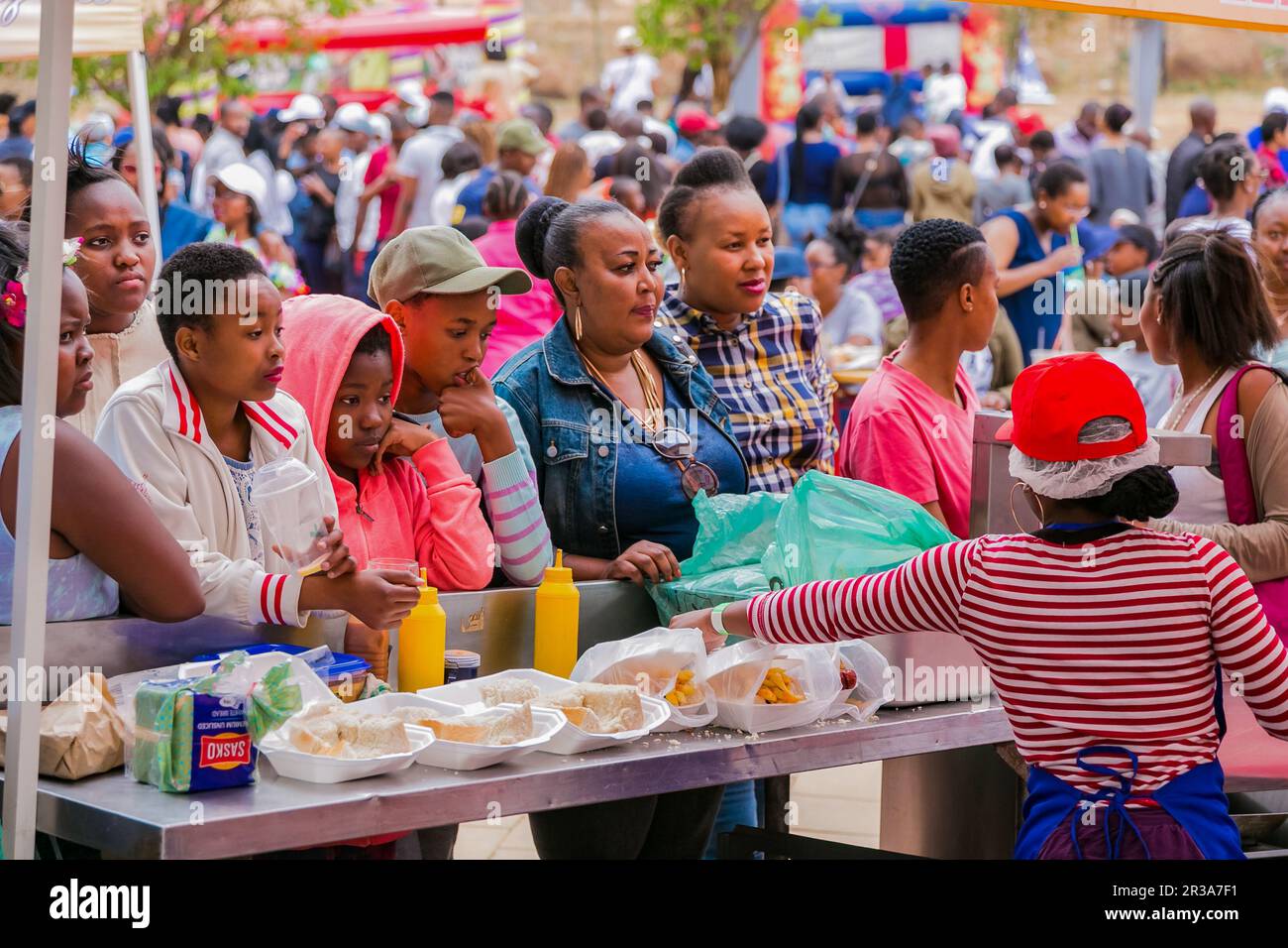 Vielfältige afrikanische Menschen bei einem Open-Air-Festival mit Straßenessen auf Brotbasis Stockfoto