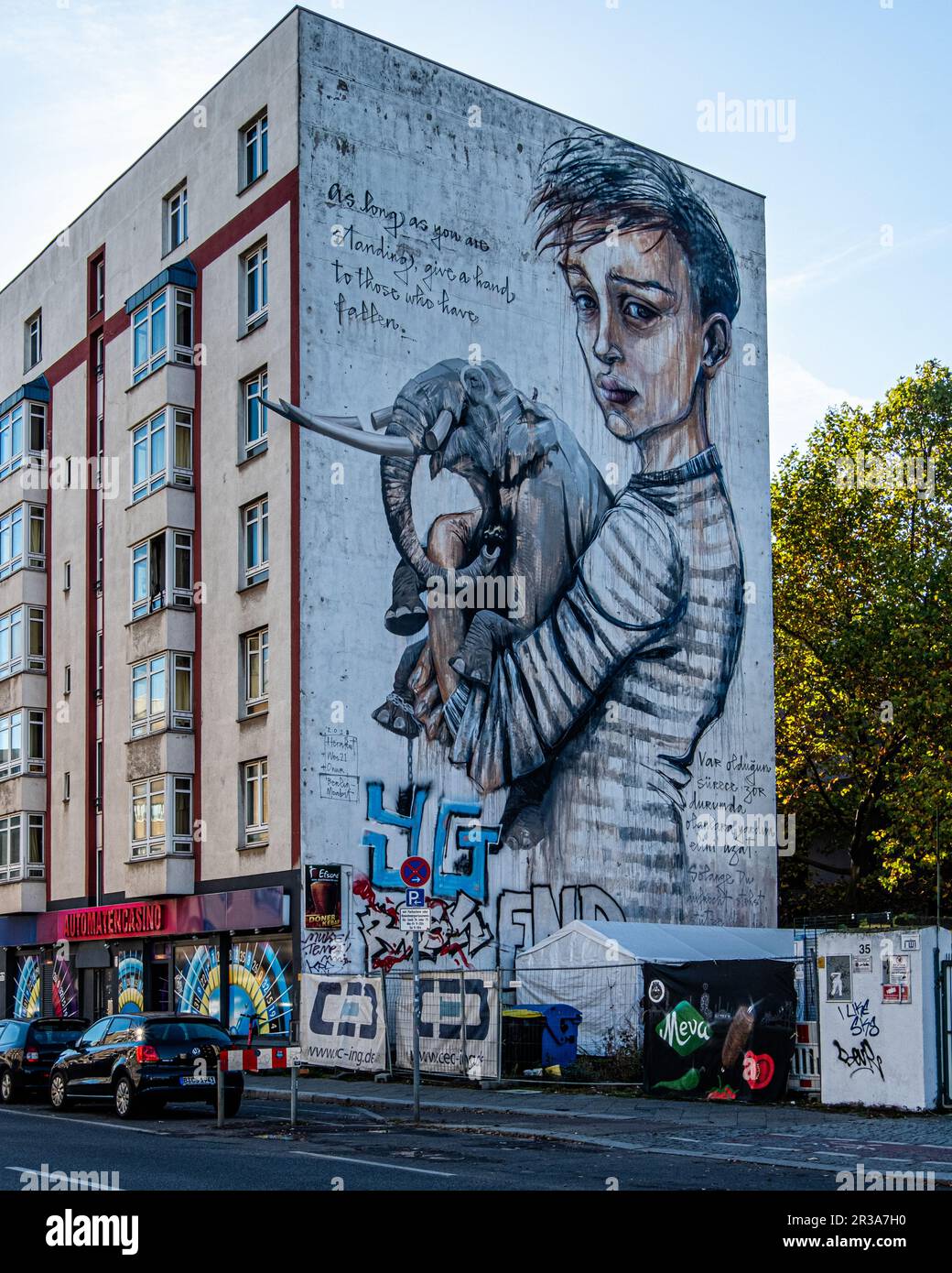 Boy Holding Elephant, Urban Art on Building Firewall, Moabit-Mitte, Berlin, Deutschland. Solange du stehst, hilf denen, die gefallen sind Stockfoto