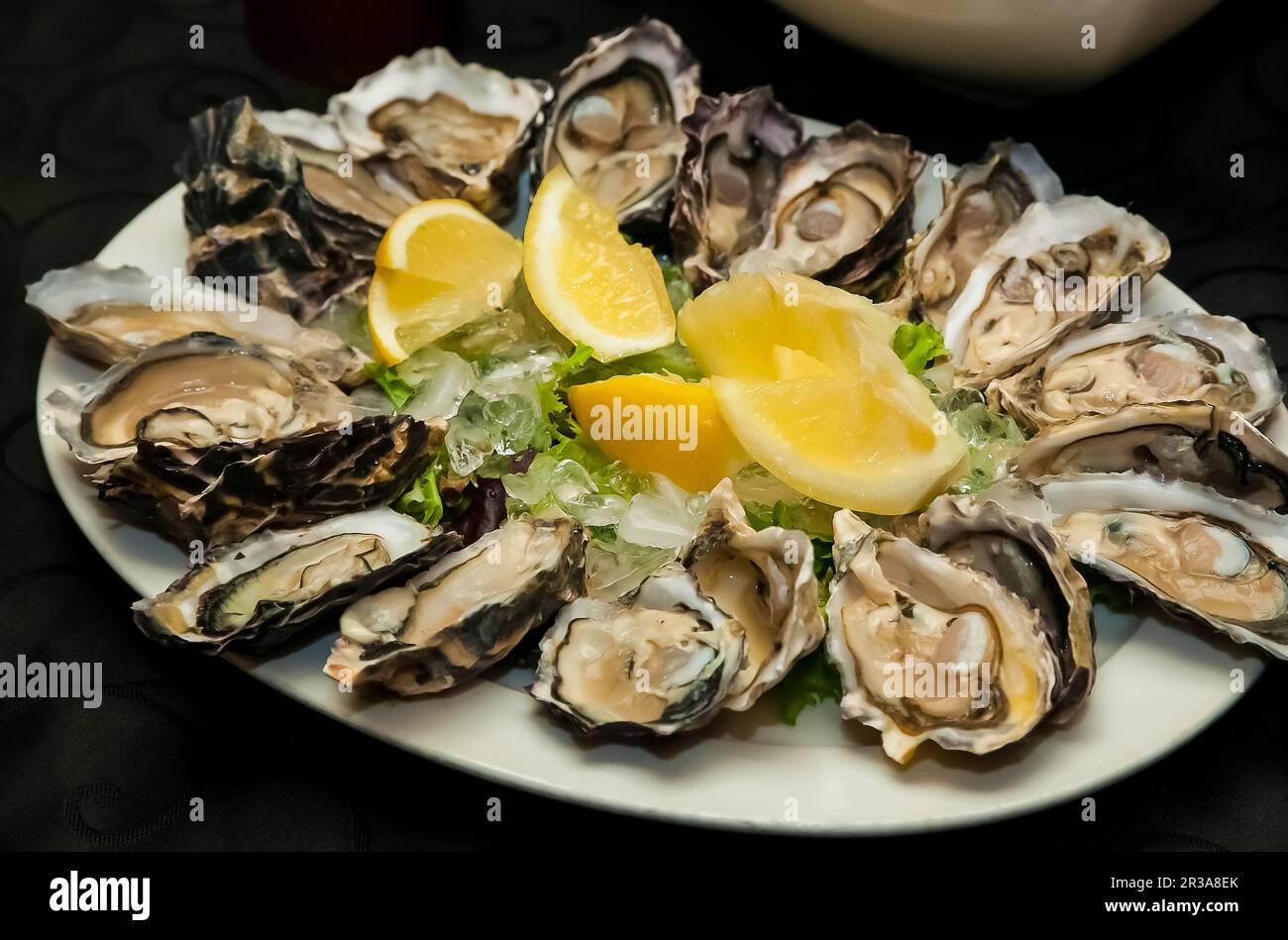Frische Meeresfrüchte, Austern und Zitrone auf Eis für Catering Stockfoto