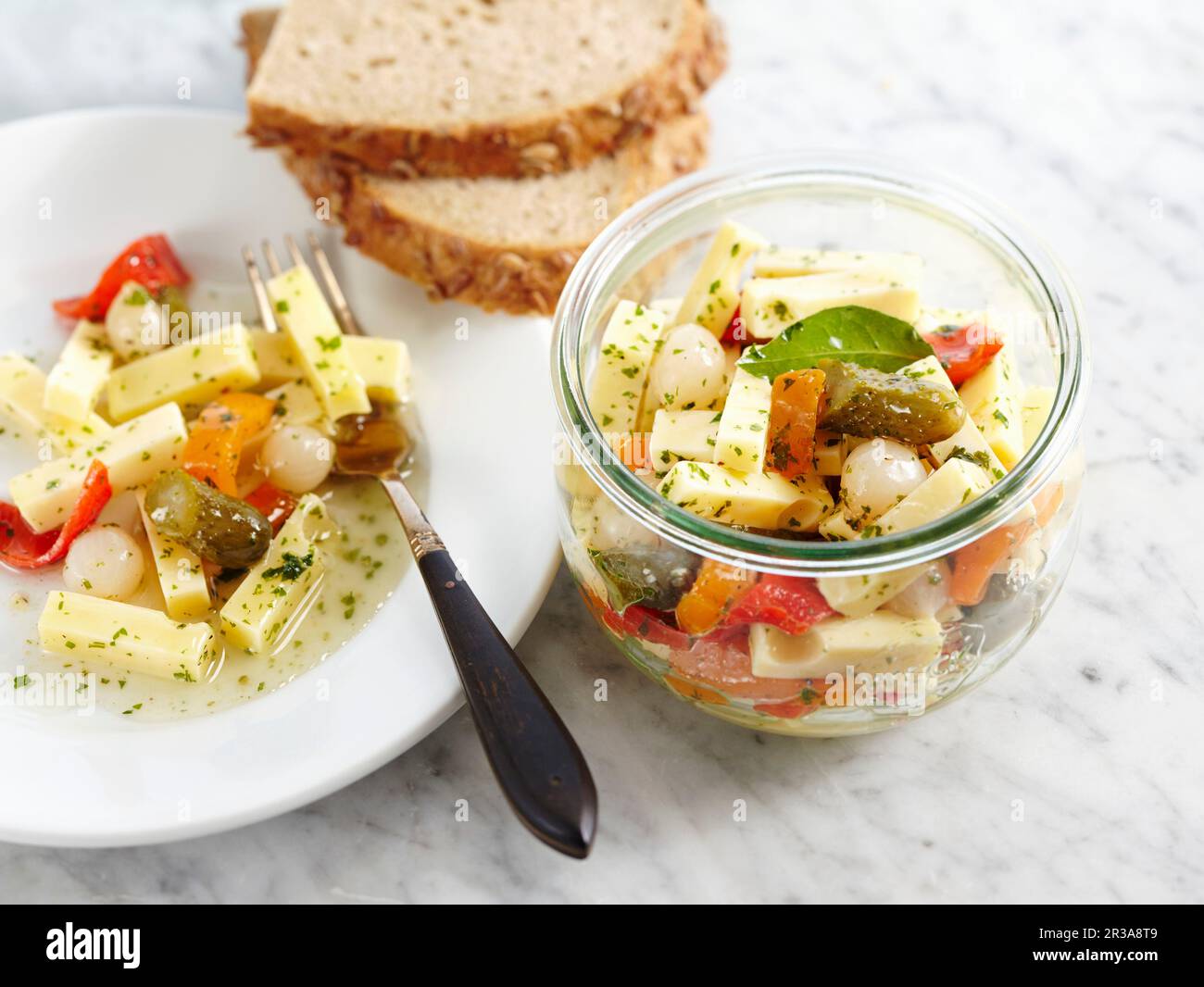 Würziger eingelegter Emmentaler Käse in Essig und Öl, Gewürzgurken, Perlzwiebeln und Paprika Stockfoto